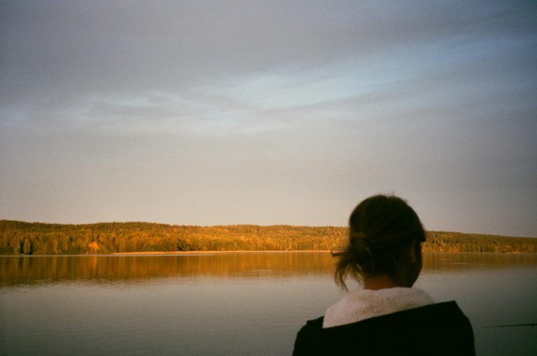 Persona reflexionando frente a un paisaje tranquilo, simbolizando la gestión emocional consciente.